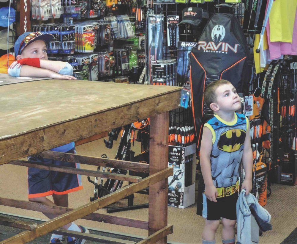 Kid bored in archery shop
