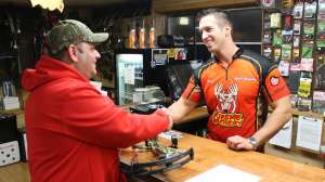 Archery shop owner and customer