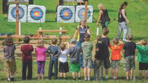 Children learning archery at outdoor range