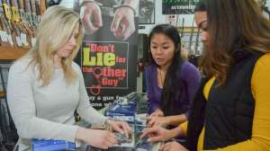 Customers 1 women in gun shop buying at counter NSSF photo