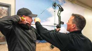 Cropped SGS98 Al Kraus Black Hills Archery assists a customer with setting the peep sight correctly copyright
