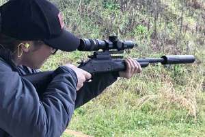 Woman target shooting rifle suppressor optics hearing protection f4159788da6a13a05c7755e7e3b29890