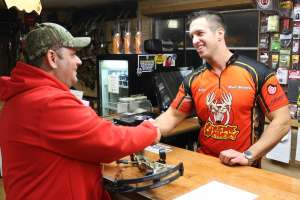 Archery shop owner and customer