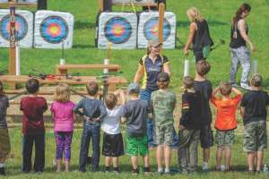 Children learning archery at outdoor range