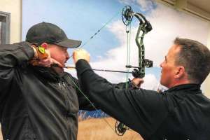 Cropped SGS98 Al Kraus Black Hills Archery assists a customer with setting the peep sight correctly copyright