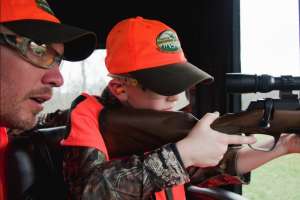 Youth hunter aiming rifle